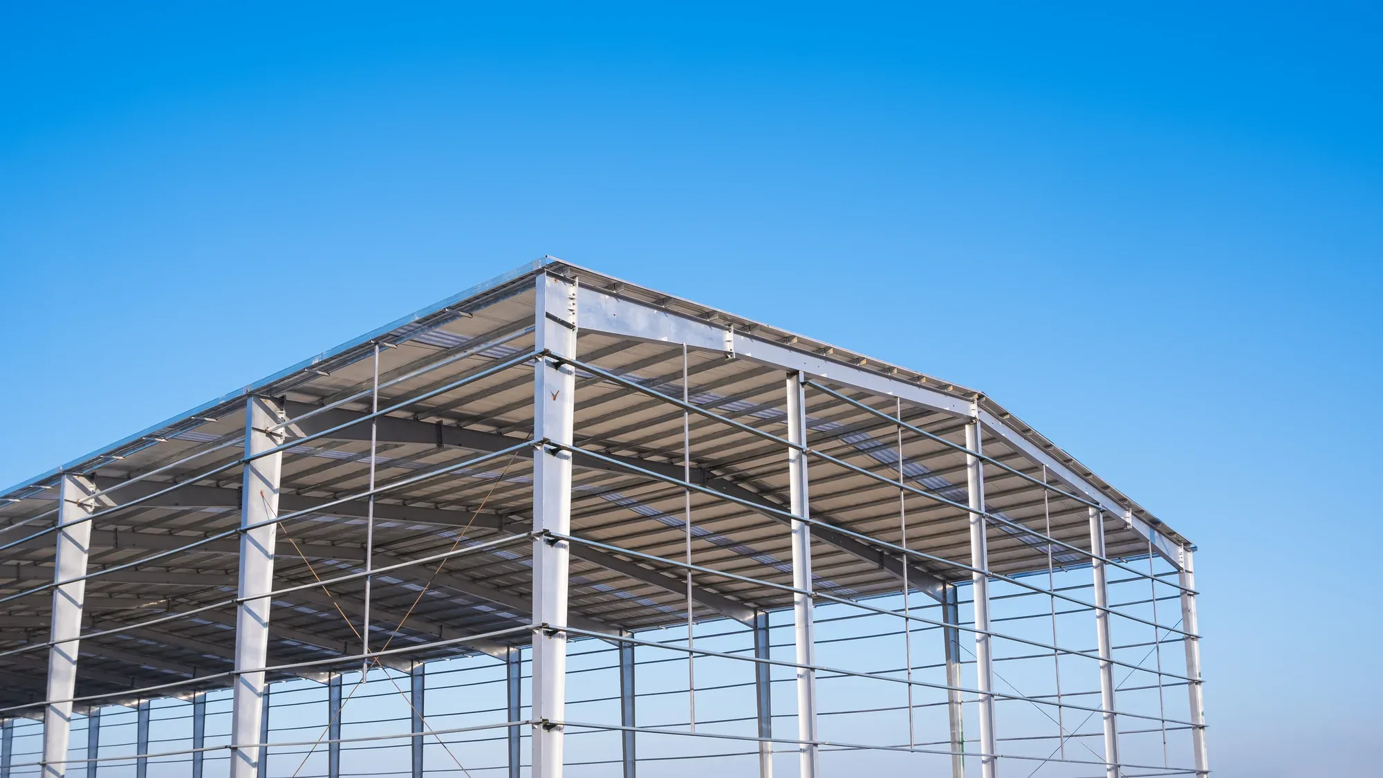 Steel building frame with purlins under a clear blue sky